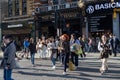 Busy crossroads with pedestrians tourists and cars in front of Tottenham Court Road Station, Central London, UK