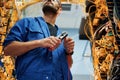 Busy by cutting the wire. Young man is working with internet equipment in server room Royalty Free Stock Photo