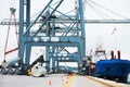 A busy day in the harbour. A massive cargo ship moored at the harbor while being loaded with containers. Royalty Free Stock Photo