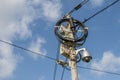 Busy electricity line and security camera against blue sky. Royalty Free Stock Photo