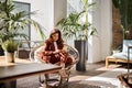 Busy middle aged business woman using phone sitting in chair in office. Royalty Free Stock Photo