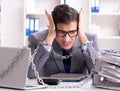 Busy employee chained to his office desk Royalty Free Stock Photo