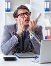 Busy employee chained to his office desk Royalty Free Stock Photo