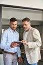 Busy executive business team of two men working on tab standing in office. Royalty Free Stock Photo