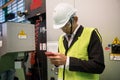 Busy factory manager check smartphone at machine