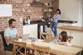 Busy Family Home With Father Working As Mother Prepares Meal Royalty Free Stock Photo