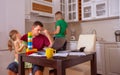 Busy Family Home with Father Working as Mother Prepares Meal