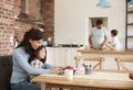 Busy Family Home With Mother Working As Father Prepares Meal