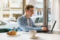 Busy glad millennial caucasian guy freelancer in glasses, typing on computer, work