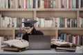 Busy graduate reading books at library Royalty Free Stock Photo