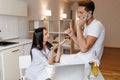 Busy guy talking on phone during lunch with wife in home. Frustrated young woman looks at boyfriend with unhappy face Royalty Free Stock Photo