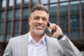 Busy happy middle aged business man making call talking on phone outdoors. Royalty Free Stock Photo