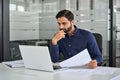 Busy Indian business man employee participating hybrid meeting in office. Royalty Free Stock Photo