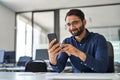 Busy Indian business man executive using mobile phone working in office. Royalty Free Stock Photo