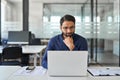 Busy Indian business man thinking on data management working on laptop. Royalty Free Stock Photo