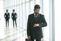 Busy indian businessman looking at wristwatch while hurrying on meeting in office. Young man in business suit checks time left to Royalty Free Stock Photo