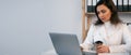 Busy Indian female doctor drinking coffee tea having break while working at hospital on laptop Royalty Free Stock Photo