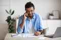 Freelancer Guy Checking Papers And Talking On Cellphone, Working At Home Office Royalty Free Stock Photo