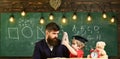 Busy kid studying at school. Father checking homework, helps to boy, son. Individual studying concept. Teacher in formal Royalty Free Stock Photo