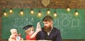 Busy kid studying at school. Father checking homework, helps to boy, son. Individual studying concept. Teacher in formal Royalty Free Stock Photo