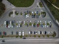 Busy large modern carpark with symmetrical roads rows of parking bays lots of symmetry and colours aerial view from