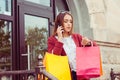 Busy life. Woman with shopping bags talking at phone coming out from store looking at her wrist watch being late to a meeting Royalty Free Stock Photo