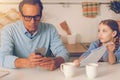 Loving daughter asking her ignoring father to look at picture Royalty Free Stock Photo
