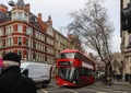 Busy London intersection on overcast wet winter day with people on bikes and double decker bus on the street - selective focus Royalty Free Stock Photo