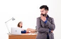 Busy man. Confident business man and pretty secretary in office. Bearded man looking at sexy woman working in background