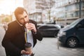 Busy man is in a hurry, he does not have time, he is going to eat snack on the go. Worker eating, drinking coffee Royalty Free Stock Photo