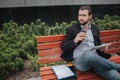 Busy man is in a hurry, he does not have time, he is going to eat snack outdoors. Worker eating and working with Royalty Free Stock Photo