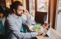 Busy man is in a hurry, he does not have time, he is going to eating and working. Worker eating, drinking coffee Royalty Free Stock Photo