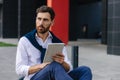 Busy man working on digital tablet outside his office Royalty Free Stock Photo