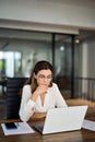 Busy mature business woman working in office using laptop thinking. Royalty Free Stock Photo