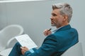 Busy Mature businessman workingon with documents while sitting in modern coworking