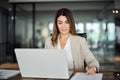 Busy mid aged business woman working in office using laptop writing notes. Royalty Free Stock Photo