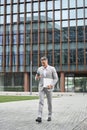 Busy middle aged business man using phone walking on city street, full body. Royalty Free Stock Photo