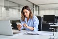 Busy middle aged business woman using mobile phone working in office. Royalty Free Stock Photo