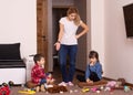 Busy mom. Mom tired to tidy up the house. Child scattered toys. Mess in the house. Royalty Free Stock Photo