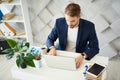 Concentrated man working at laptop with attention