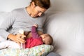 Busy mother breastfeeding her newborn baby while using an manual  breast pump to use milk in feeding bottle when she is working Royalty Free Stock Photo