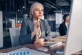 Busy muslim businesswoman in hijab working on computer while sitting in modern office Royalty Free Stock Photo