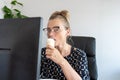 A busy office woman eats ice cream at her workplace without interrupting work Royalty Free Stock Photo