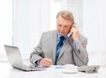 Busy older businessman with laptop and telephone Royalty Free Stock Photo