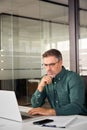 Busy older mature business man looking at laptop working at office desk. Royalty Free Stock Photo