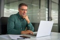 Busy older professional business man looking at laptop working at office desk. Royalty Free Stock Photo