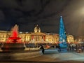 A busy outdoor Christmas market on Trafalgar Square in front of The National Gallery with the illuminated Christmas tree Royalty Free Stock Photo