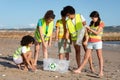 Busy positive international teenager schoolchildren volunteers in uniform collect garbage and plastic bottles