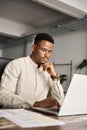 Busy African business man investor thinking working on laptop, vertical. Royalty Free Stock Photo