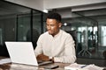 Busy professional male African company employee using laptop working in office. Royalty Free Stock Photo